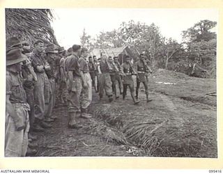 KIARIVU, NEW GUINEA, 1945-08-14. A SECTION OF 2 NEW GUINEA BATTALION TROOPS MARCHING TO KIAP HOUSE TO FORM PART OF THE GUARD OF HONOUR AT THE CEREMONY IN WHICH THE UNION JACK WAS HOISTED AT THE ..