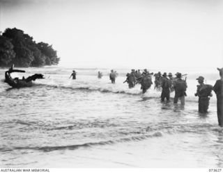 GURUM RIVER, NEW GUINEA. 1944-05-28. FORWARD TROOPS OF THE 35TH INFANTRY BATTALION CROSS THE MOUTH OF THE GURUM RIVER AT THE RIVER BAR ADJOINING THE SEA. THE UNIT IS ADVANCING UP THE COAST TOWARDS ..