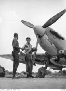 KIRIWINA, TROBRIAND ISLANDS, PAPUA. 1944-01-11. LEADING AIRCRAFTMAN V. N. SMITH OF SOUTH YARRA, VIC, AND OF NO. 79 (SPITFIRE) SQUADRON RAAF, HAGGLES WITH A NATIVE ABOUT THE PRICE OF A FOWL WHILE ..