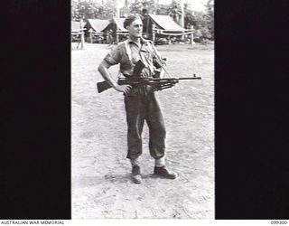 RABAUL, NEW BRITAIN, 1945-12-06. A BREN GUNNER DEMONSTRATING THE STANDING POSITION FOR FIRING FROM THE HIP DURING A DEMONSTRATION OF VARIOUS INFANTRY WEAPONS