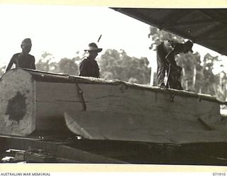 LAE, NEW GUINEA. 1944-03-30. NX163900 SAPPER C. BUNNER (1), WITH VX144654 SAPPER R.J. O'BRIEN (2), WATCH FLITCH TIMBER COMING OFF A LOG CUT WITH A 48 INCH CANADIAN TWIN SAW IN A SAWMILL AT THE 59TH ..