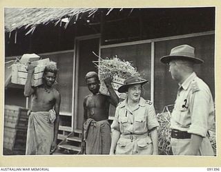 LAE, NEW GUINEA, 1945-05-06. LIEUTENANT-COLONEL M.J. SPENCER, ASSISTANT CONTROLLER OF AUSTRALIAN WOMEN'S ARMY SERVICE (1), TALKING TO CAPTAIN R. GENTILES (2), DURING PREPARATIONS FOR THE ARRIVAL OF ..