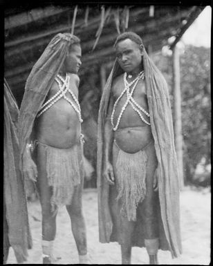 Two Kukukuku men wearing long bark rain hoods, Salamaua, New Guinea, 1933 / Sarah Chinnery