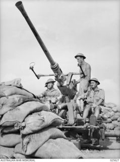 PORT MORESBY, PAPUA. 1942-07. INSIDE THE SAND-BAGGED GUN-PIT, FROM WHERE AUSTRALIAN ANTI-AIRCRAFT GUNNERS KEEP WATCH ON NEW GUINEA SKIES