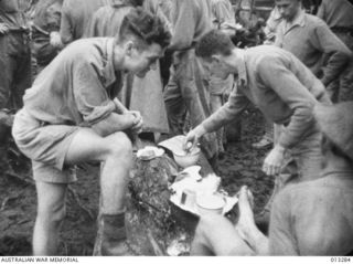 Wounded receiving treatment as an Australian unit leaves a forward area for a well-earned spell. The soldier front left is believed to be SX13157 Private John Charles Smith, 2/6 Field Ambulance