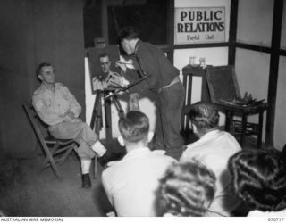 PORT MORESBY, PAPUA, NEW GUINEA, 1944-02-02. VX93433 CAPTAIN W.A. DARGIE (1), OFFICIAL WAR ARTIST, MILITARY HISTORY SECTION, LECTURING AND DEMONSTRATING PORTRAIT PAINTING USING QX27970 SERGEANT W. ..