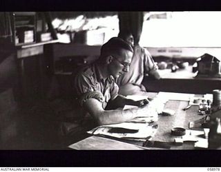 NEW GUINEA. 1943-10. PORTRAIT OF TX1716 SERGEANT F. R. MUSSON AT WORK IN THE AUSTRALIAN MILITARY HISTORY SUBSECTION OFFICE