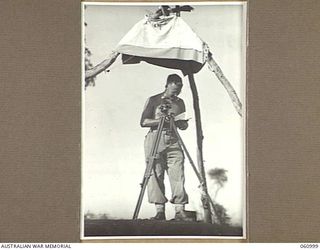 DONADABU AREA, NEW GUINEA. 1943-12-01. VX18535 LANCE SERGEANT R. P. MURPHY OF NO. 7 BATTERY, 2/4TH AUSTRALIAN FIELD REGIMENT, USING A DIRECTOR RE SECTION INSTRUMENT TO PLOT THE EXACT POSITION OF ..