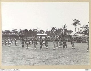 HERBERTON, QLD. 1945-01-20. THE REGIMENTAL BAND, 2/9 CAVALRY (COMMANDO) REGIMENT PLAYING BAGPIPES ON THE MARCH. THEY ARE PARTICIPATING IN THE 9 DIVISION GYMKHANA AND RACE MEETING AT THE HERBERTON ..