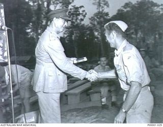 THE SOLOMON ISLANDS, 1945-01-12. A NEW ZEALAND WINNER RECEIVES HIS REWARD AT A COMBINED ANZAC SPORTS MEETING AT BOUGAINVILLE ISLAND. (RNZAF OFFICIAL PHOTOGRAPH.)