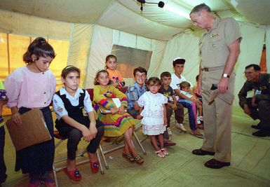 US NAVY Admiral (ADM) Joseph W. Prueher, Commander in CHIEF U.S. Pacific Command visits with Kurdish children in a hospital tent at Andersen Air Force Base, Guam, during OPERATION PACIFIC HAVEN. The tents are used for routine physical examinations and immunization of Kurdish evacuees being temporarily housed at Andersen AFB. Pacific Haven, a joint humanitarian operation conducted by the U.S. Military, evacuated over 2,100 Kurds from Northern Iraq. The evacuees will be housed temporarily at Andersen AFB, Guam, while they go through the immigration process for residence into the United States