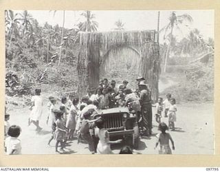 RATONGOR, NEW BRITAIN, 1945-10-10. CHINESE CHILDREN CLAMOUR ENTHUSIASTICALLY TO HAVE THE NEXT RIDE IN A JEEP DRIVEN BY A MEMBER OF 11 DIVISION. THE JEEP ACTED AS A TYPE OF UNOFFICIAL MERRY-GO-ROUND ..