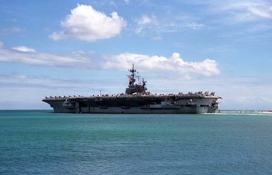 Crew members man the rails aboard the aircraft carrier USS RANGER (CV-61) as the ship departs Pearl Harbor through the channel.