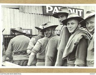 HERBERTON, QLD. 1943-06-12. WINNERS COLLECTING FROM THE TOTALIZATOR AT THE RACE MEETING ORGANISED BY THE 6TH AUSTRALIAN DIVISION