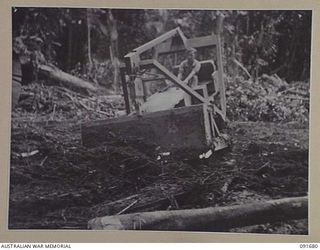 SORAKEN AREA, BOUGAINVILLE. 1945-05-04. PRIVATE F.E. SCHIPKE, 16 FIELD COMPANY, ROYAL AUSTRALIAN ENGINEERS, HANDLING A BULLDOZER TO CLEAR STUMPS DURING THE CONSTRUCTION OF THE EAST WEST TRAIL. THE ..