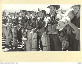 CAIRNS, QLD. 1944-10-30. TROOPS OF BRIGADE HEADQUARTERS 2/4 INFANTRY BATTALION AWAIT THE ORDER TO EMBARK ABOARD THE USS MEXICO DURING MOVEMENT OF ELEMENTS OF 6 DIVISION TO NEW GUINEA. IDENTIFIED ..