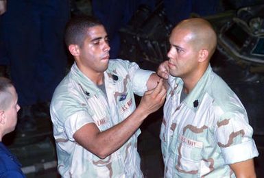 US Navy (USN) Hospital Corpsman (HM) Kawika T. Segundo from Maui, Hawaii, with the Amphibious Assault Vehicle (AVV) platoon Company "E" Battalion Landing Team, 2nd Battalion, 2nd Marines, 24th Marine Expeditionary Unit (MEU), gets "Frocked" to Hospital Corpsman Third Class (HM3), while standing on an Amphibious Assault Vehicle (AAV) in the well deck of the USS TORTUGA (LSD-46) Dock Landing ship