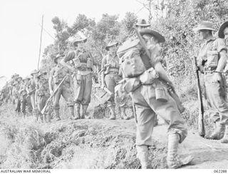 SHAGGY RIDGE, NEW GUINEA. 1943-12-27. PERSONNEL OF D COMPANY 2/16TH AUSTRALIAN INFANTRY BATTALION, 21ST AUSTRALIAN INFANTRY BRIGADE MOVING ALONG A TRACK ON THEIR WAY TO THE FRONT LINE DURING THE ..