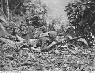 BUSU RIVER, NEW GUINEA. 1944-10-07. TROOPER J. SELL, 2/8TH CAVALRY COMMANDO SQUADRON TAKES UP AN ATTACKING POSITION IMMEDIATELY AFTER CROSSING THE RIVER DURING AN ARMY-AIR CO-OPERATION TRAINING ..