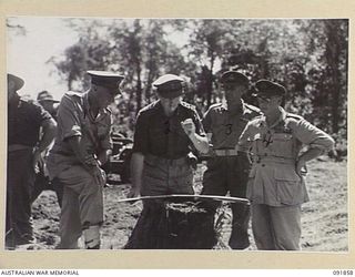 BOUGAINVILLE. 1945-05-12. LIEUTENANT GENERAL V.A.H. STURDEE, GENERAL OFFICER COMMANDING FIRST ARMY (1), WITH SENIOR OFFICERS, LOOKING AT BATTLE MAP AT HIRU HIRU, DURING HIS VISIT TO HEADQUARTERS 15 ..