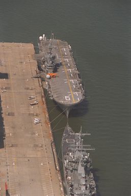 An aerial view of pier #11 at the Norfolk Naval Base showing the amphibious assault ship USS GUAM (LPH-9) and the nuclear-powered guided missile cruiser USS MISSISSIPPI (CGN-40) tied up on the north side of the pier