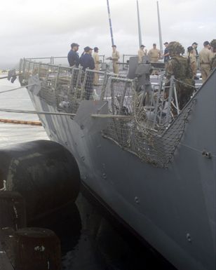 An starboard side stern deck view onboard the USS HOPPER (DDG 70) showing Lance Corporal (LCPL) Paliwoedinsci, USMC, assigned to L/Company, 3rd Battalion, 3rd Marines Regiment, manning a .50 caliber Machine Gun as USN and USMC personnel conduct training onboard the ship