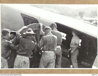 WARD'S DROME, NEW GUINEA. 1943-11-16. TROOPS OF THE 2/5TH AUSTRALIAN FIELD REGIMENT, 7TH AUSTRALIAN DIVISION PLACING THE PLATFORM OF A DISMANTLED LONG 25-POUNDER GUN INTO A DOUGLAS TRANSPORT ..