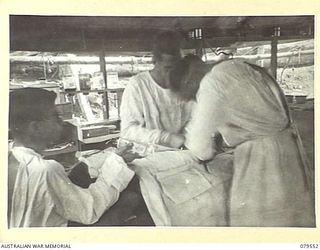 ORO BAY, NEW GUINEA. 1943-07. VX112273 CAPTAIN W.E. SPRING, SURGEON (FOREGROUND) OPERATING ON A PATIENT IN THE MAIN DRESSING STATION OF THE 10TH FIELD AMBULANCE