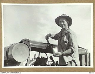 MILNE BAY, NEW GUINEA, 1943-07-12. VX106436 LANCE CORPORAL A. METZENTHEN OF NO. 2 SECTION, 4TH AUSTRALIAN FIELD COMPANY, ROYAL AUSTRALIAN ENGINEERS, CLEANING AIR COMPRESSOR