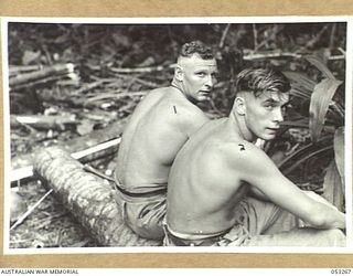 MILNE BAY, NEW GUINEA. 1943-06-30. W11222 GUNNER J.G. SHERRY (LEFT) AND WX14091 SAPPER N. PALMER OF "C" GROUP, 2/3RD AUSTRALIAN DOCKS OPERATING COMPANY, ROYAL AUSTRALIAN ENGINEERS, ENJOY A SPELL ..