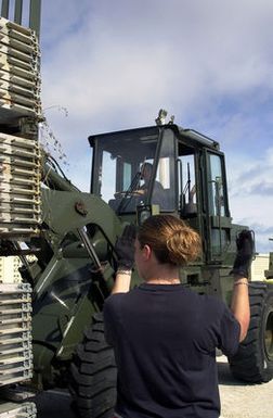 US Air Force (USAF) SENIOR AIRMAN (SRA) Amy Christopherson, from Elmendorf Air Force Base (AFB), directs STAFF Sergeant (SSGT) Allan Abistado, from Yokota Air Base (AB), Japan, as he drives a 10K All Terrain (AT) forklift and moves cargo pallets at Andersen Air Force Base (AFB), Guam