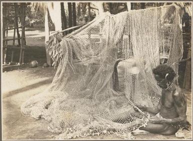 Glimpses around Wanigella [Wanigela], [man with a net] Frank Hurley