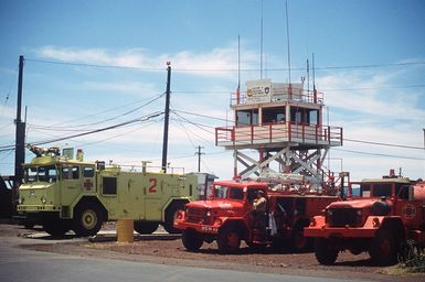 Fire trucks stand by near the control tower during the joint airborne/air transportability training exercise