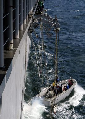 During a man overboard drill the US Navy (USN) Landing Craft Personnel Large (LCPL) is lowered over the side of the USN Tarawa Class Amphibious Assault Ship USS SAIPAN (LHA 2)