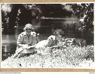 KOITAKI, NEW GUINEA. 1944-01-02. AUSTRALIAN WOMEN'S ARMY SERVICE PERSONNEL OF THE 47TH AUSTRALIAN CAMP HOSPITAL, QFX25390 PRIVATE M. BALDWIN (LEFT); QFX25404 PRIVATE V. PARKER; ENJOY THEIR REST DAY ..