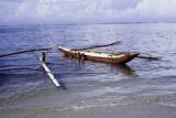 French Polynesia, children swimming by canoes off Moorea Island