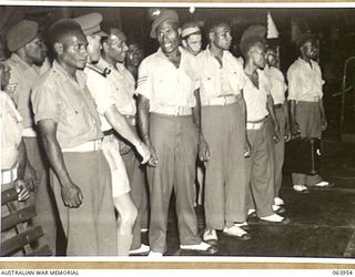 NEWCASTLE, NSW. 1944-01-28. AUSTRALIAN AND NEW GUINEA ADMINISTRATION UNIT NATIVES WATCHING A WIRE MAKING MACHINE IN OPERATION AT THE BROKEN HILL PTY. MILLS