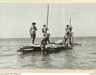 PORT MORESBY, PAPUA. 1942-07-20. PUNTING THEIR "LAKATOI", (NATIVE NAME FOR A SAILING CRAFT) THESE AUSTRALIAN SOLDIERS PUSH OUT THROUGH THE SHALLOWS ON A FISHING EXCURSION. THE NATIVE SAILING CRAFT ..