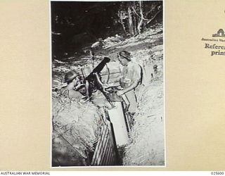 PORT MORESBY, PAPUA. 1942-07. A WELCOME FOR THE JAPS. CONCEALED AMONG TROPICAL FOLIAGE, THIS AUSTRALIAN MACHINE GUN POST IS READY TO MEET ANY JAPANESE ADVANCE IN NEW GUINEA