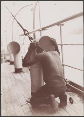 A Melanesian boy looking down the cabin ventilator on the Southern Cross, 1906 / J.W. Beattie