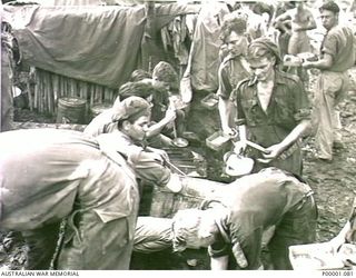 THE SOLOMON ISLANDS, 1945-03-27. AUSTRALIAN ARMY MEAL LINE AT A CAMP SITE ON THE NUMA NUMA TRAIL ON BOUGAINVILLE ISLAND. (RNZAF OFFICIAL PHOTOGRAPH.)