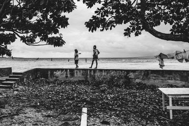 Children walking along sea wall, Nukunonu, Tokelau