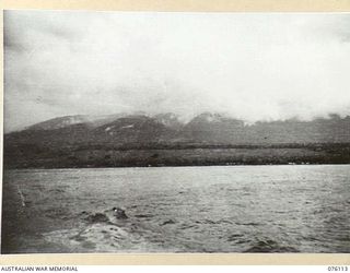 KARKAR ISLAND, NEW GUINEA. 1944-10-20. THE DOGAWAN PLANTATION VIEW FROM A BARGE LEAVING THE ISLAND. NATIVES WORKING UNDER THE DIRECTION OF THE AUSTRALIAN NEW GUINEA ADMINISTRATIVE UNIT ARE CLEARING ..