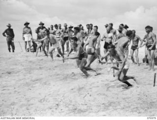 KELANOA, NEW GUINEA, 1944-02-20. MEMBERS OF THE 2/4TH LIGHT ANTI-AIRCRAFT REGIMENT, ROYAL AUSTRALIAN ARTILLERY, THE TEAM NEAREST THE CAMERA, ARE PICTURED WINNING THE RELAY RACE AT THE 5TH ..