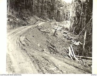 WAMPIT, NEW GUINEA. 1944-03-01. A ROAD SHELF IN AN OPERATIONAL AREA OF HEADQUARTERS, COMMANDER ROYAL ENGINEERS (A.I.F.), ON THE WAU - LAE SECTION 64 1/2 MILES FROM WAU. THE ROAD WILL BE 18 FEET ..