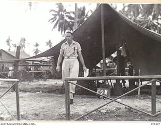 MADANG, NEW GUINEA. 1944-08-15. NX117687 WARRANT OFFICER II, A.S. WOOLASTON, COMPANY SERGEANT MAJOR, 165TH GENERAL TRANSPORT COMPANY, OUTSIDE HIS TENT OFFICE