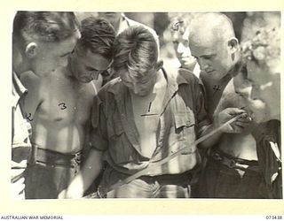 ALEXISHAFEN, NEW GUINEA. 1944-05-17. NX120484 PRIVATE H. BATISTE (1), SHOWING FELLOW MEMBERS OF THE 35TH INFANTRY BATTALION A JAPANESE SAMURAI SWORD HE ACQUIRED NORTH OF ALEXISHAFEN. IDENTIFIED ..