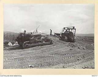 WEWAK AREA, NEW GUINEA. 1945-05-30. A BULLDOZER OF 2/2 FIELD COMPANY ROYAL AUSTRALIAN ENGINEERS, WORKING ON A CORAL PIT. THE CORAL IS SCRAPED UP TO THE "CHINAMAN" AND PUSHED THROUGH A TRAP ON TO ..