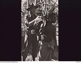 NADZAB, NEW GUINEA. 1943-09-19. NX454 LIEUTENANT COLONEL A. F. HOBSON OBE, COMMANDING OFFICER 2/4TH AUSTRALIAN FIELD AMBULANCE MAIN DRESSING STATION, 7TH AUSTRALIAN DIVISION, ADJUSTING A PACK ON A ..