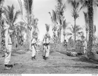 JACQUINOT BAY, NEW BRITAIN. 27 FEBRUARY 1945. N429556 CHAPLAIN N.G. PARDY, HEADQUARTERS, 5TH DIVISION READING THE BURIAL SERVICE AT THE GRAVESIDE OF PRIVATE P. FANNIN, B COMPANY 594TH ENGINEER BOAT ..